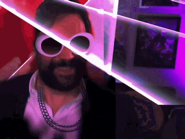 a man with a beard wearing sunglasses and a chain