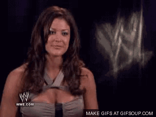 a woman is smiling in front of a sign that says wwe