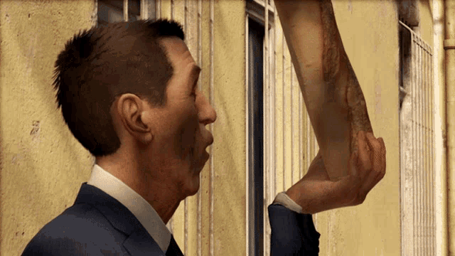 a man in a suit and tie is holding another man 's arm in his hand