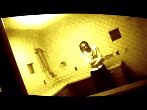 a person standing in a room with a sink and a sign that says ' exit ' on it
