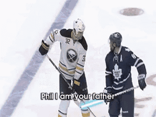 two ice hockey players are standing on the ice and one of them is talking to the other .