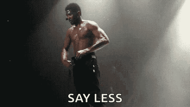 a shirtless man is standing on a stage holding a microphone .