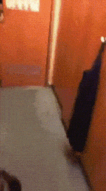 a person is walking down a hallway with a suitcase on the floor