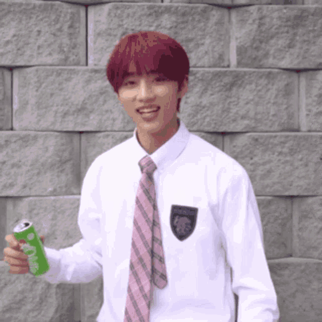 a young man with red hair wearing a white shirt and tie is holding a can of soda
