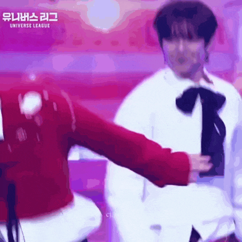a man and a woman are dancing on a stage in front of a sign that says universe league .