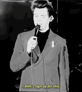 a man in a suit is singing into a microphone .