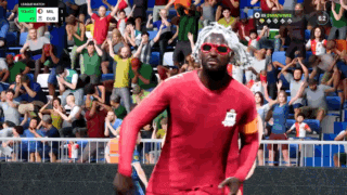 a soccer player wearing sunglasses and a red jersey stands on the field