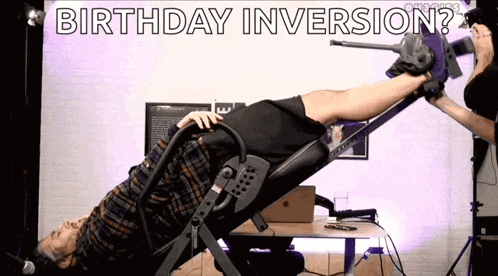 a man is laying on an inversion machine and the words birthday inversion are above him