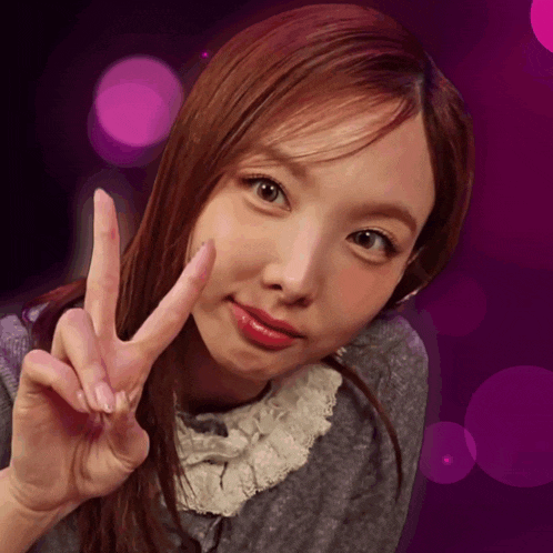 a woman making a peace sign with her hand