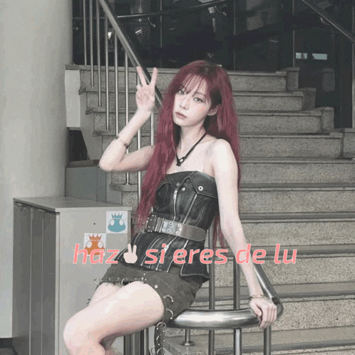 a woman with red hair is sitting on a railing with the words haz si eres de lu written on the bottom