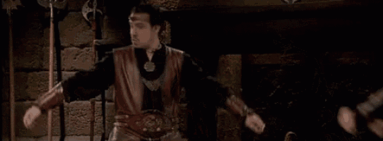 a group of men are standing next to each other in a dark room in a castle .
