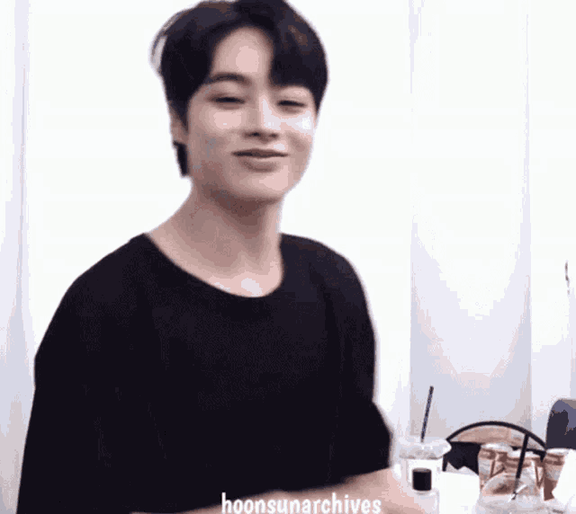 a young man wearing a black shirt with the words hoonsunarchives written on the bottom