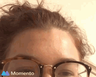 a close up of a woman 's forehead with glasses and the word momento on the bottom