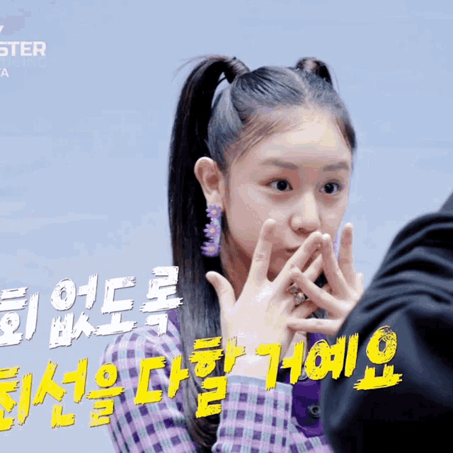 a girl covering her mouth with her hands in front of a sign that says ' ster '