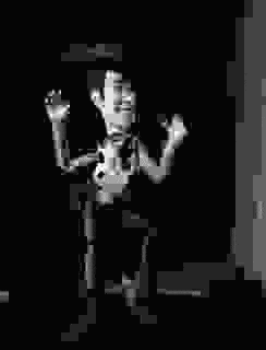 a black and white pixel art of a skeleton standing next to a door .