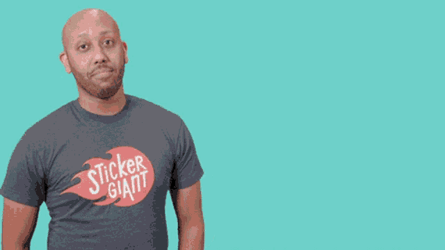 a man wearing a shirt that says sticker giant is giving a thumbs up