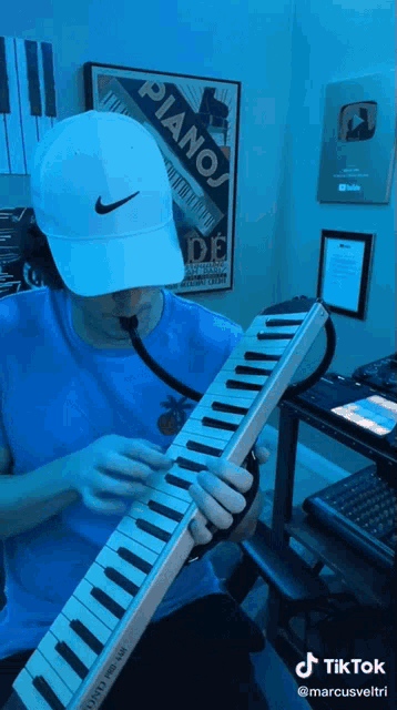 a man is playing a piano keyboard in front of a piano poster