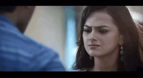 a man and a woman are looking at each other and the woman has a sad look on her face .