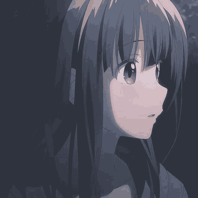 a close up of a girl 's face in a dark room with long hair .