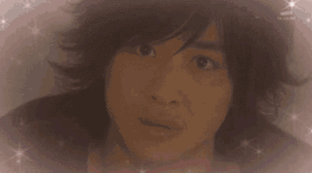 a close up of a man 's face with sparkles around it .
