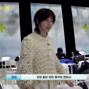 a woman in a white sweater is standing in front of a sign that says ' 방화 '