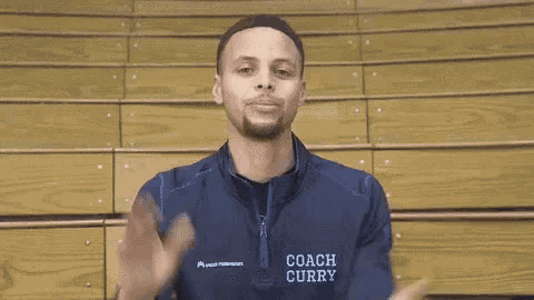 a man wearing a jacket that says coach curry on it is smiling .