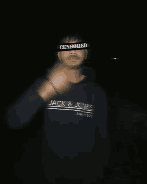 a man wearing a jack & jones sweatshirt has a censored band around his face