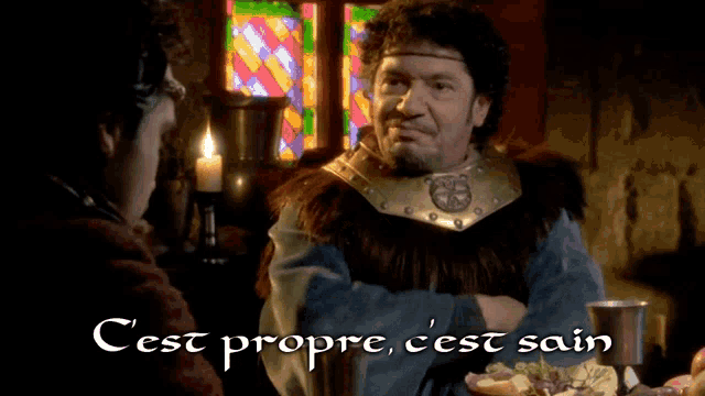 a man in a fur coat stands next to another man with the words cest propre c'est sain written below him