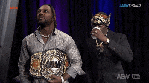 two men holding a aew wrestling championship belt
