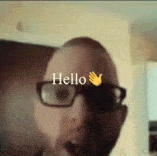 a man wearing glasses says hello with a hand
