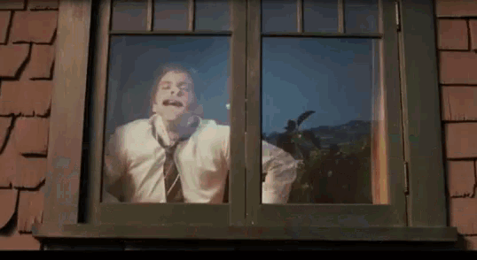 a man in a white shirt and tie is looking out a window