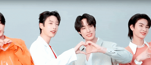 three young men are making a heart shape with their hands