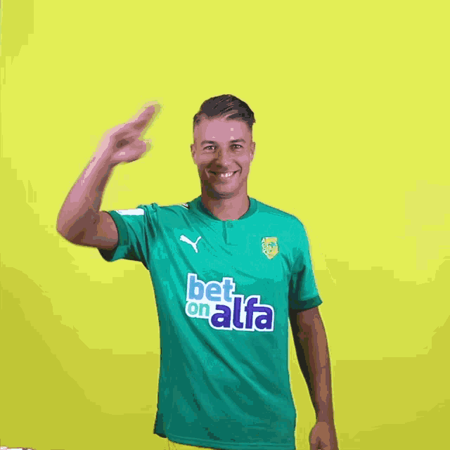 a man wearing a green bet on alfa shirt