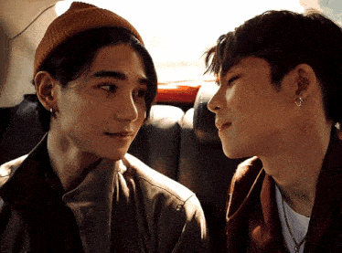 two men looking at each other in a car