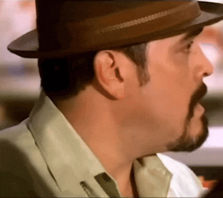 a man with a beard is wearing a hat and a white shirt .