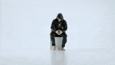 a person wearing a black hoodie with a question mark on the chest