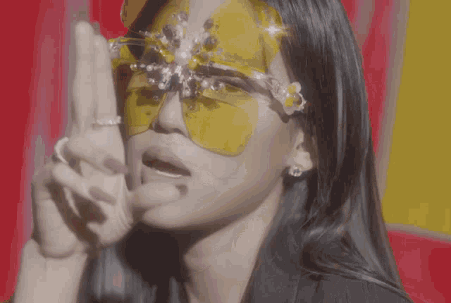 a woman wearing a pair of yellow sunglasses with flowers on them