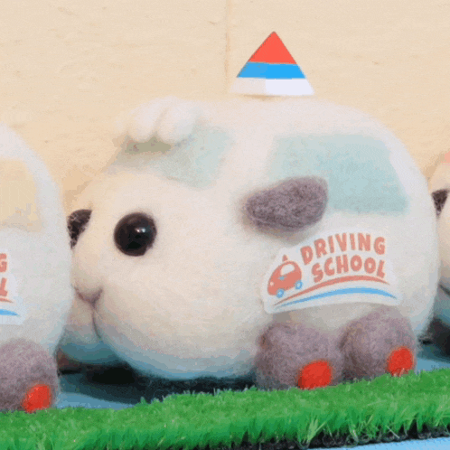 a stuffed animal with a sticker that says driving school on it