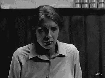 a black and white photo of a woman making a funny face .