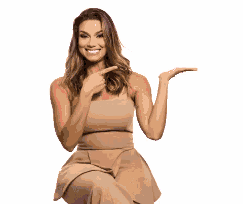 a woman in a tan dress is pointing at something in front of wed festival