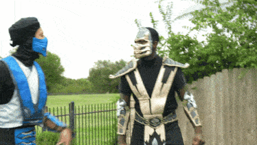 a man in a sub zero costume is standing next to a man in a scorpion costume