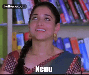 a woman in a sari is smiling in front of a bookshelf and the word nenu is on her face .