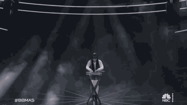 a woman with long hair is standing in front of a keyboard .