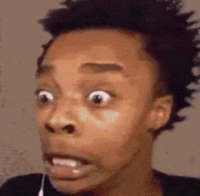 a close up of a person 's face with a surprised look on it