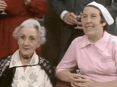 a woman in a pink shirt has a name tag on her sleeve that says ' nurse '