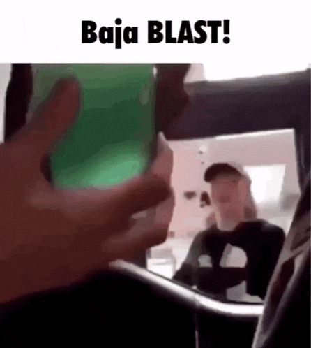 a person is taking a picture of another person in a car with a green cup .