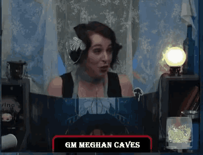 a woman is sitting in front of a screen that says gm meghan caves on it
