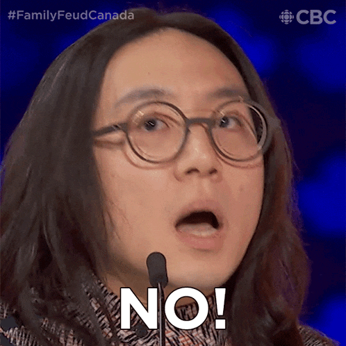 a man with long hair and glasses says " no " in front of a microphone