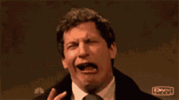 a man is making a funny face with his hands in front of his face .