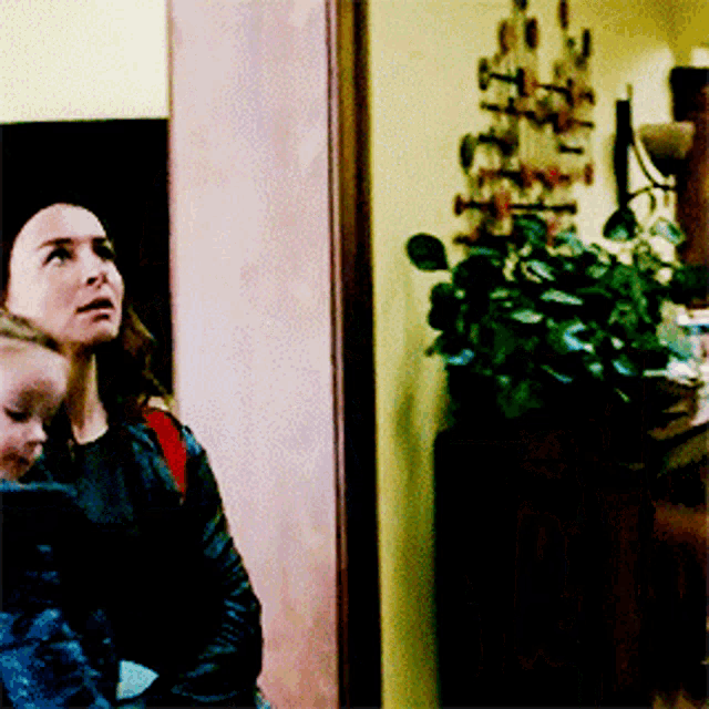 a woman is holding a child in her arms and looking up